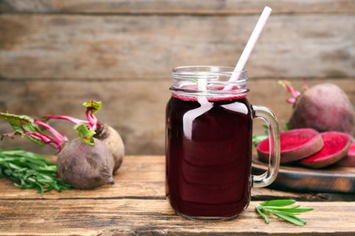 Photo of Freshly made beet juice in mason jar on wooden table