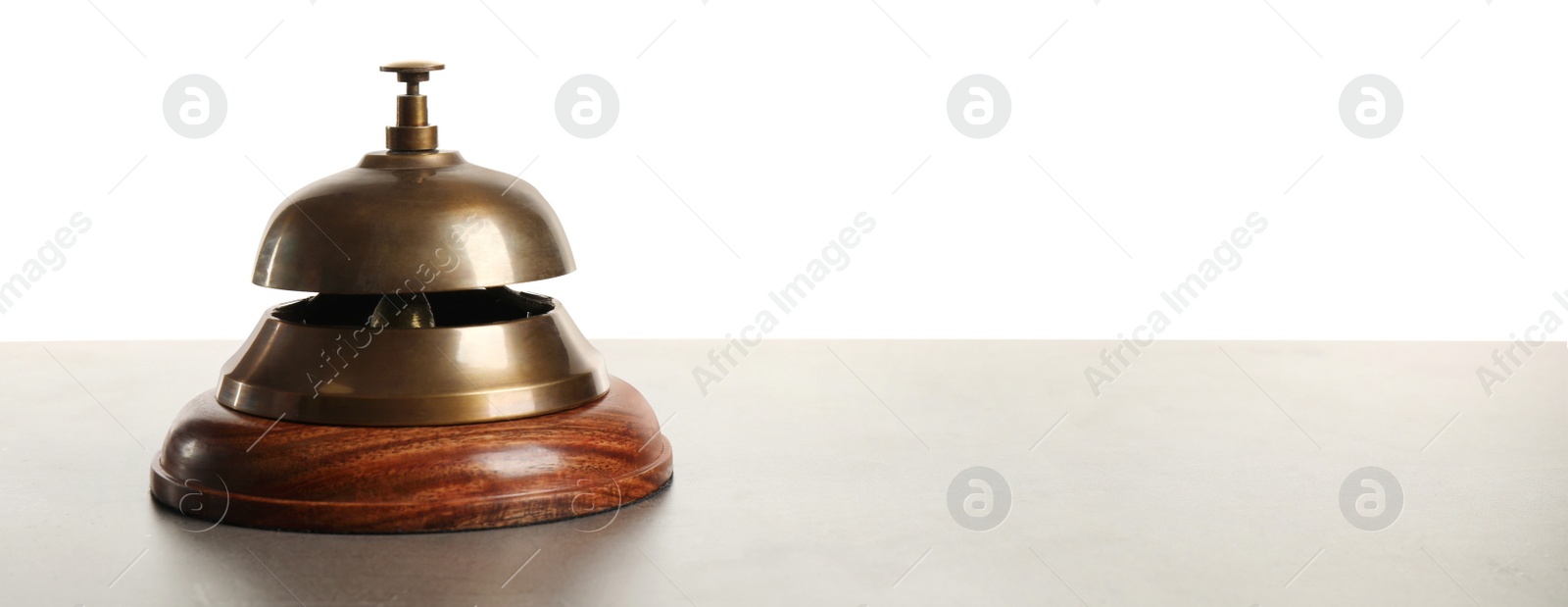 Photo of Hotel service bell on grey stone table against white background