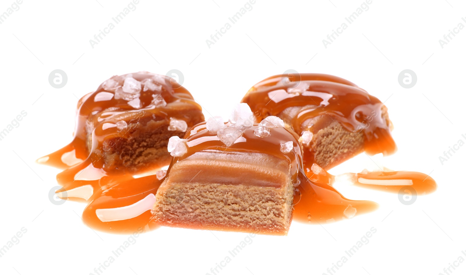 Photo of Delicious salted caramel with sauce on white background