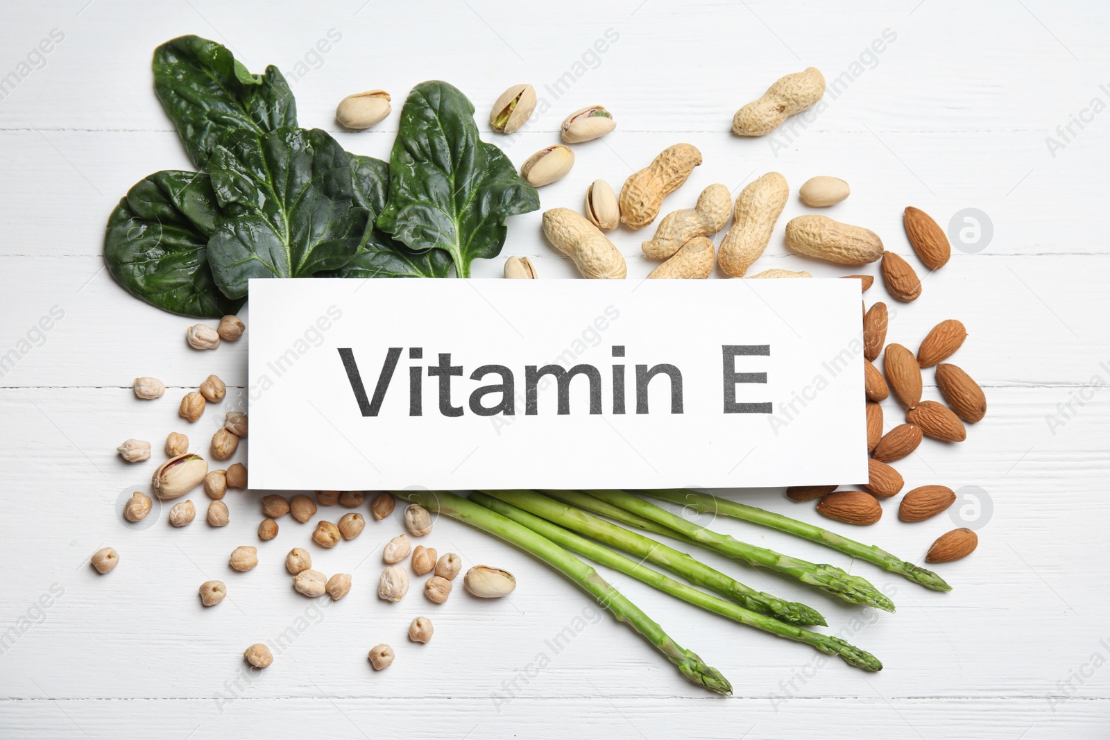 Photo of Card with phrase Vitamin E and different products on white wooden table, flat lay