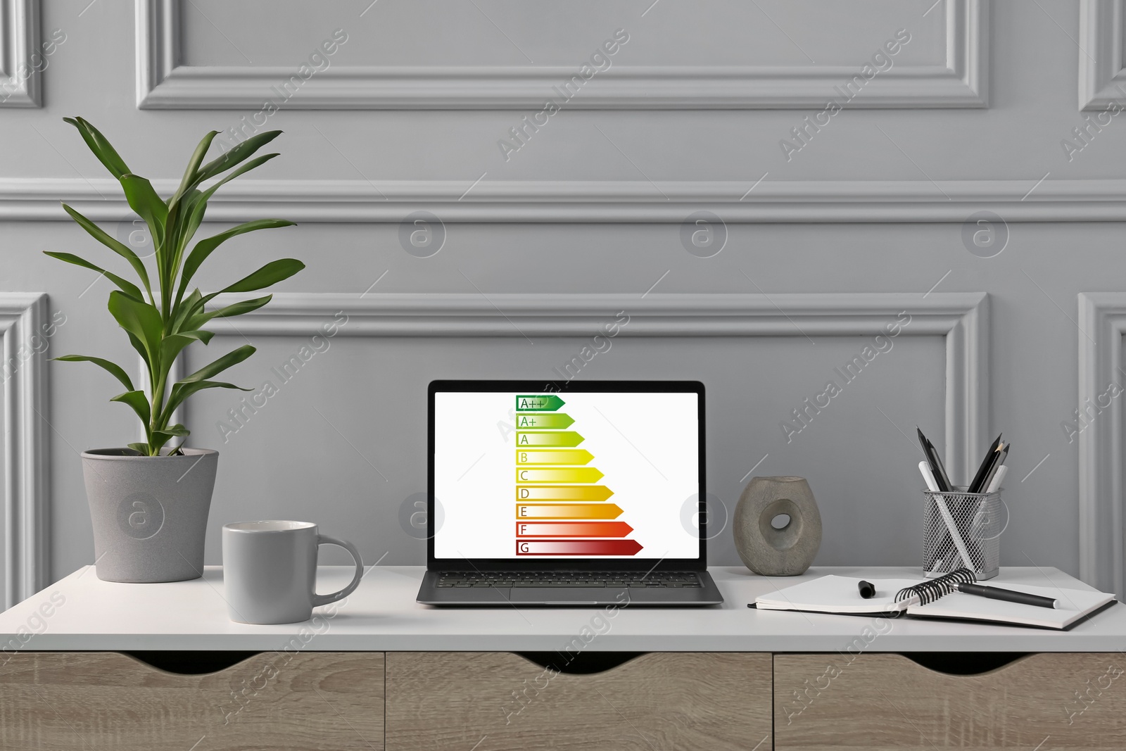 Image of Energy efficiency rating on laptop display. Workplace with modern computer