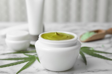 Photo of Jar of hemp cream on marble table. Organic cosmetics