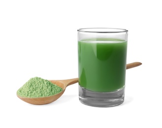 Photo of Glass of fresh wheat grass juice and spoon with powder on white background