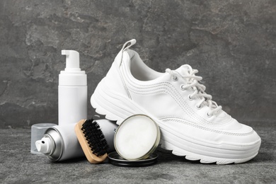 Photo of Composition with stylish footwear and shoe care accessories on grey background