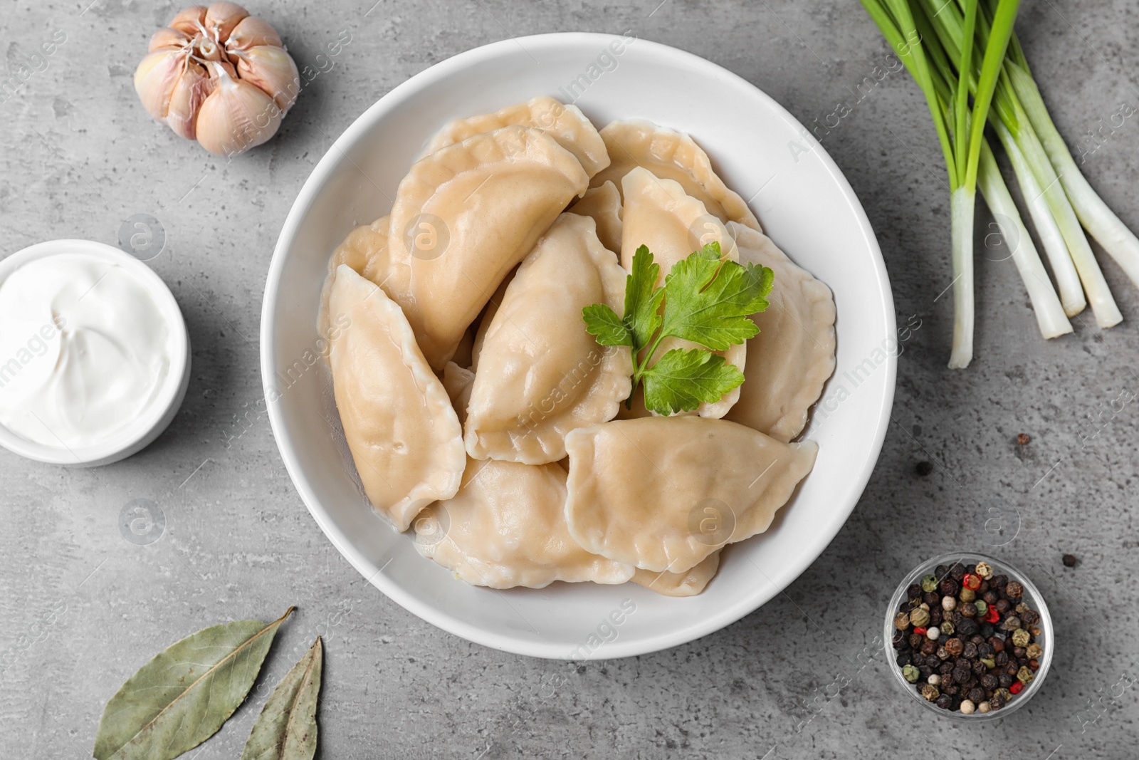 Photo of Flat lay composition with bowl of cooked dumplings on stone surface