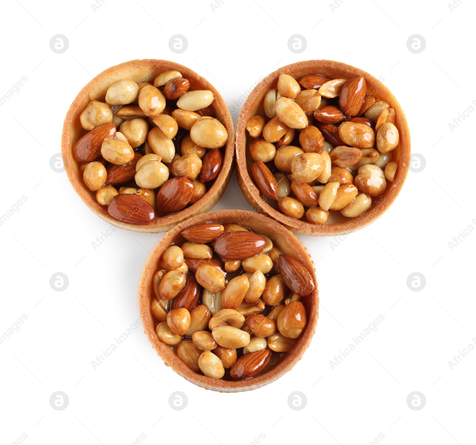 Photo of Tartlets with caramelized nuts isolated on white, top view. Tasty dessert