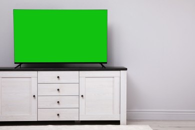 Image of Chroma key compositing. TV with mockup green screen in room. Mockup for design