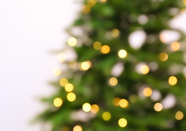 Photo of Blurred view of beautiful Christmas tree with fairy lights on white background