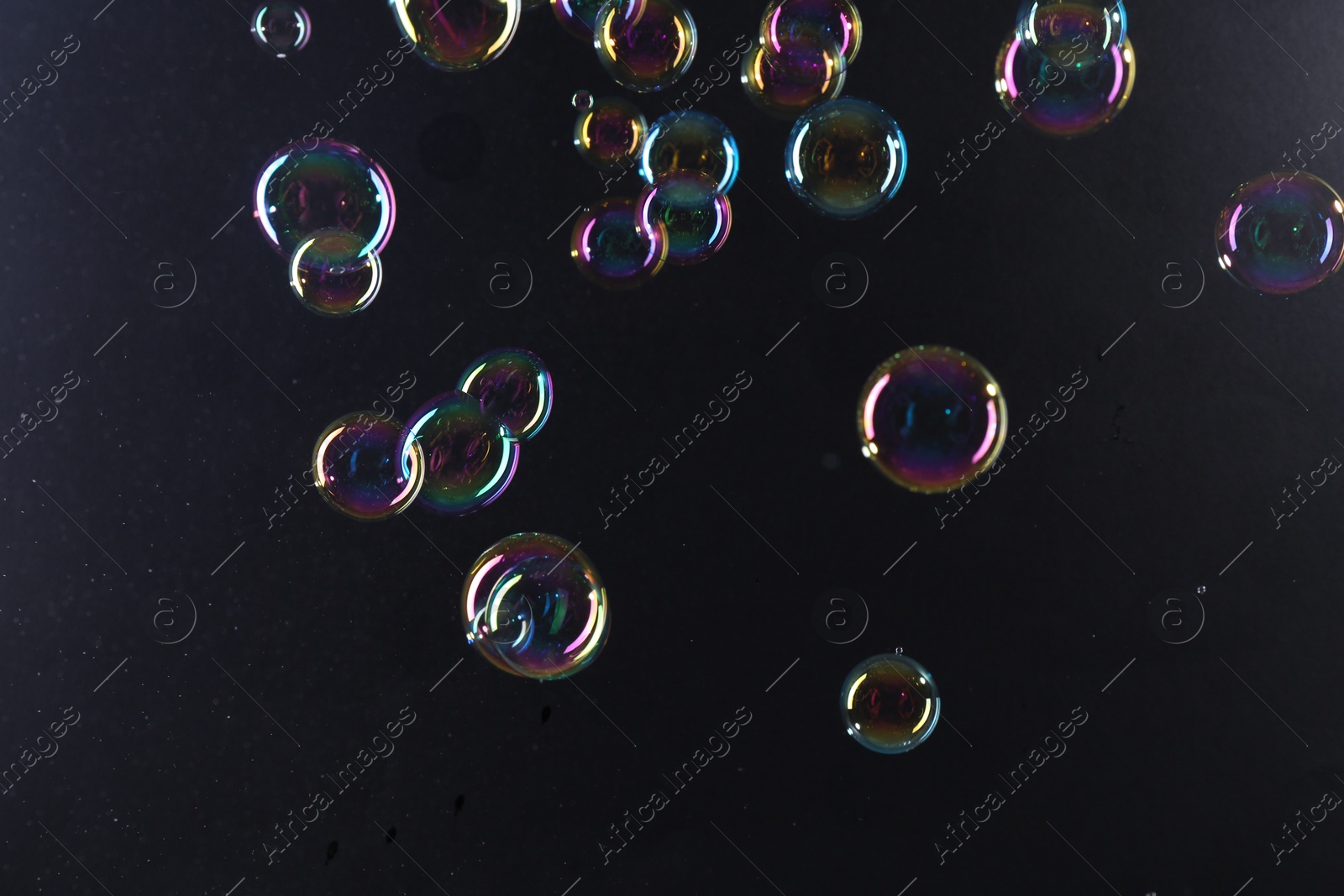 Photo of Beautiful transparent soap bubbles on dark background