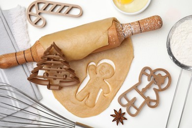 Photo of Christmas treat. Flat lay composition with cookie cutters and ingredients on white table