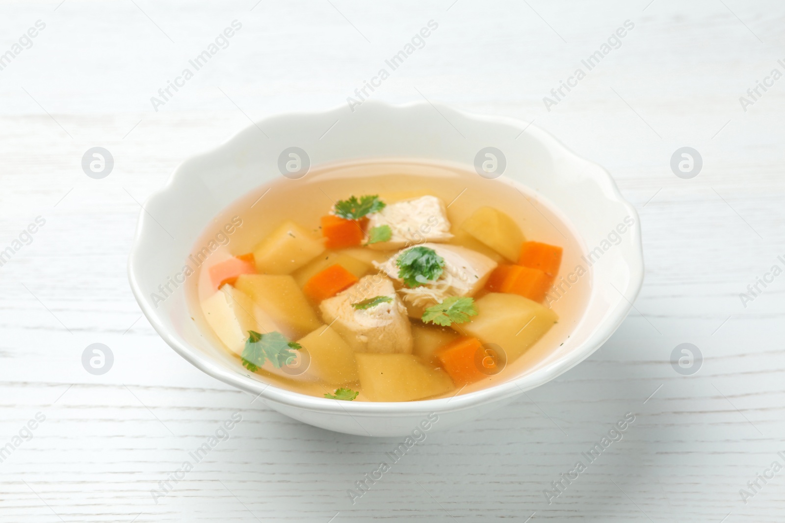 Photo of Dish with fresh homemade chicken soup on wooden table