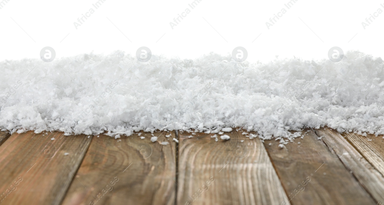 Photo of Heap of snow on wooden table against white background. Christmas season