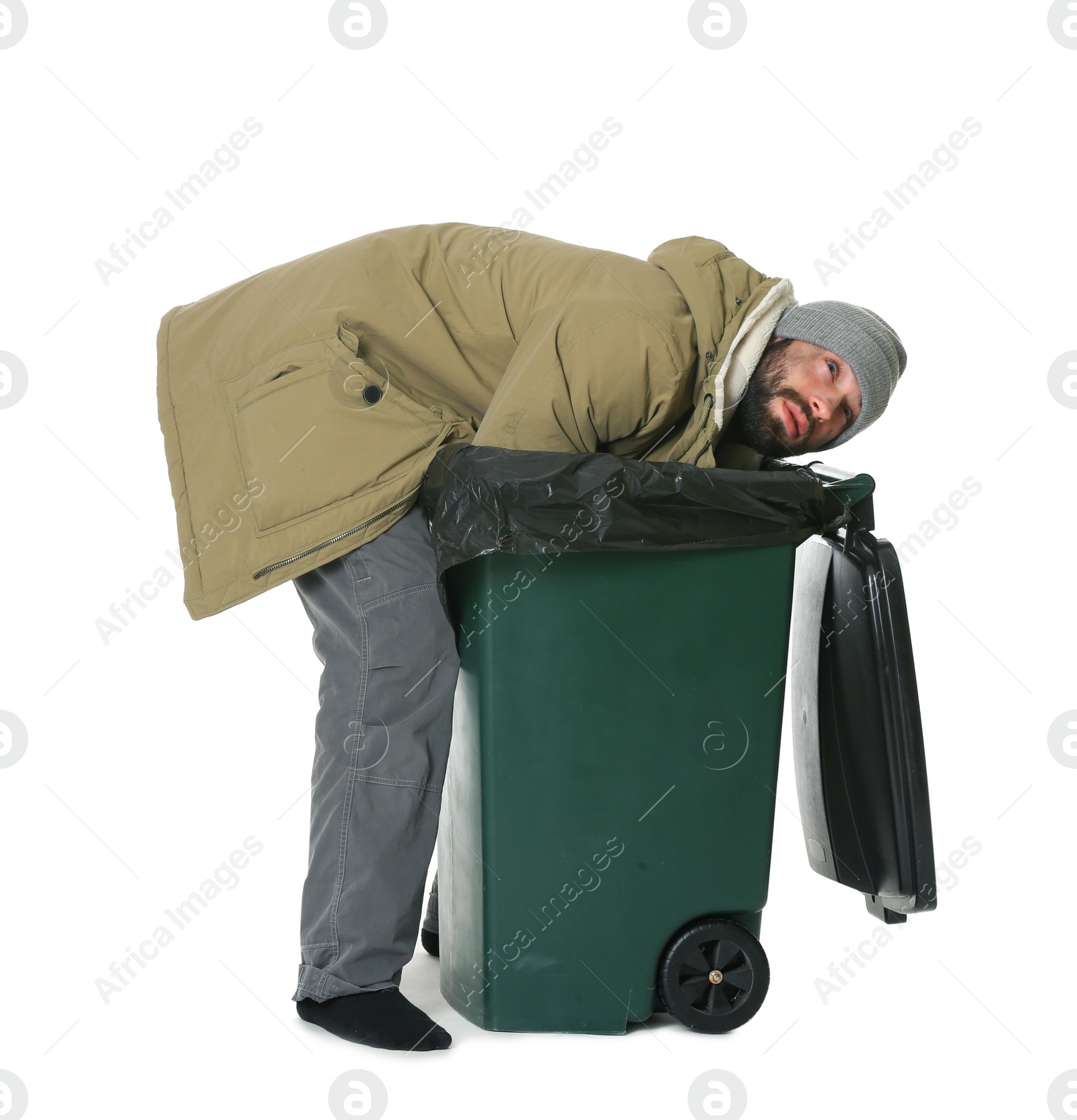 Photo of Poor homeless man digging in trash bin isolated on white