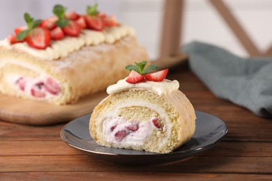 Photo of Delicious cake roll with strawberries and cream on wooden table, closeup