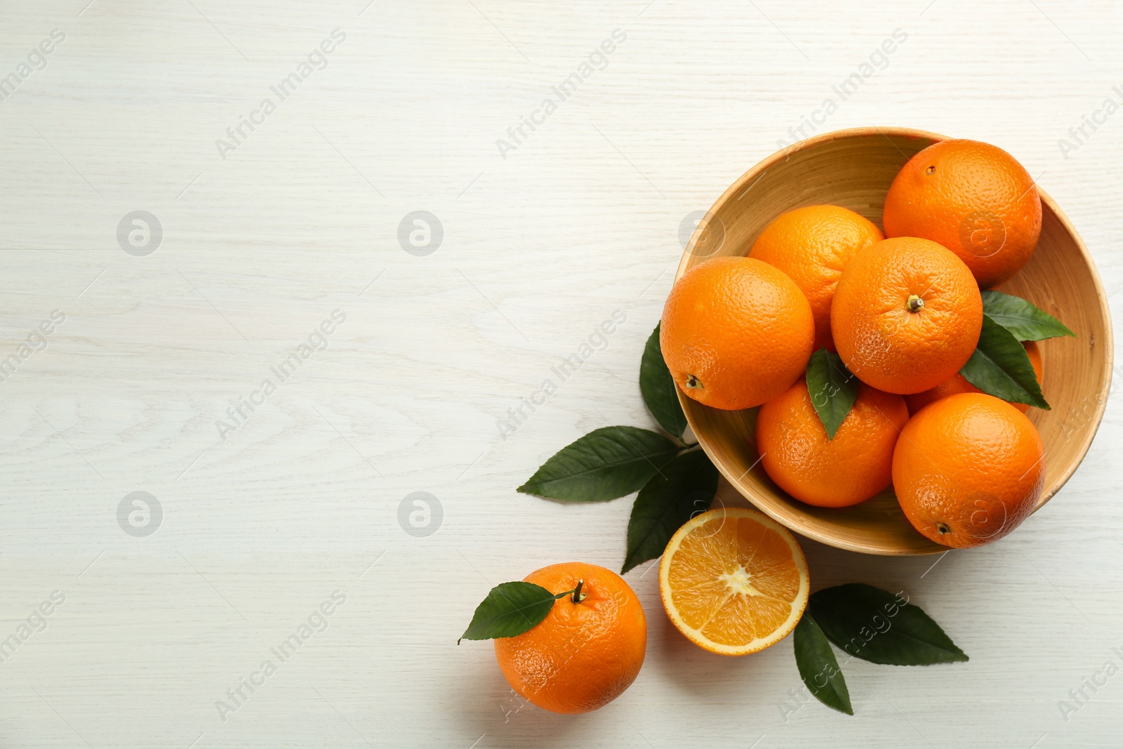 Photo of Delicious ripe oranges on white wooden table, flat lay. Space for text