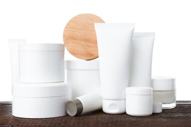 Set of different creams on wooden table against white background