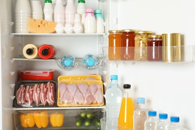 Open refrigerator with many different products, closeup