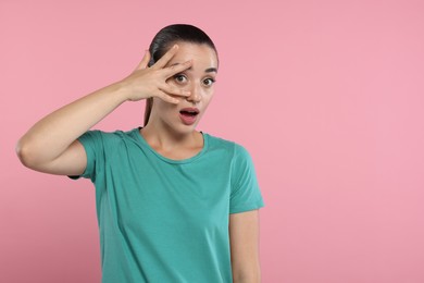 Photo of Embarrassed woman covering face on pink background. Space for text