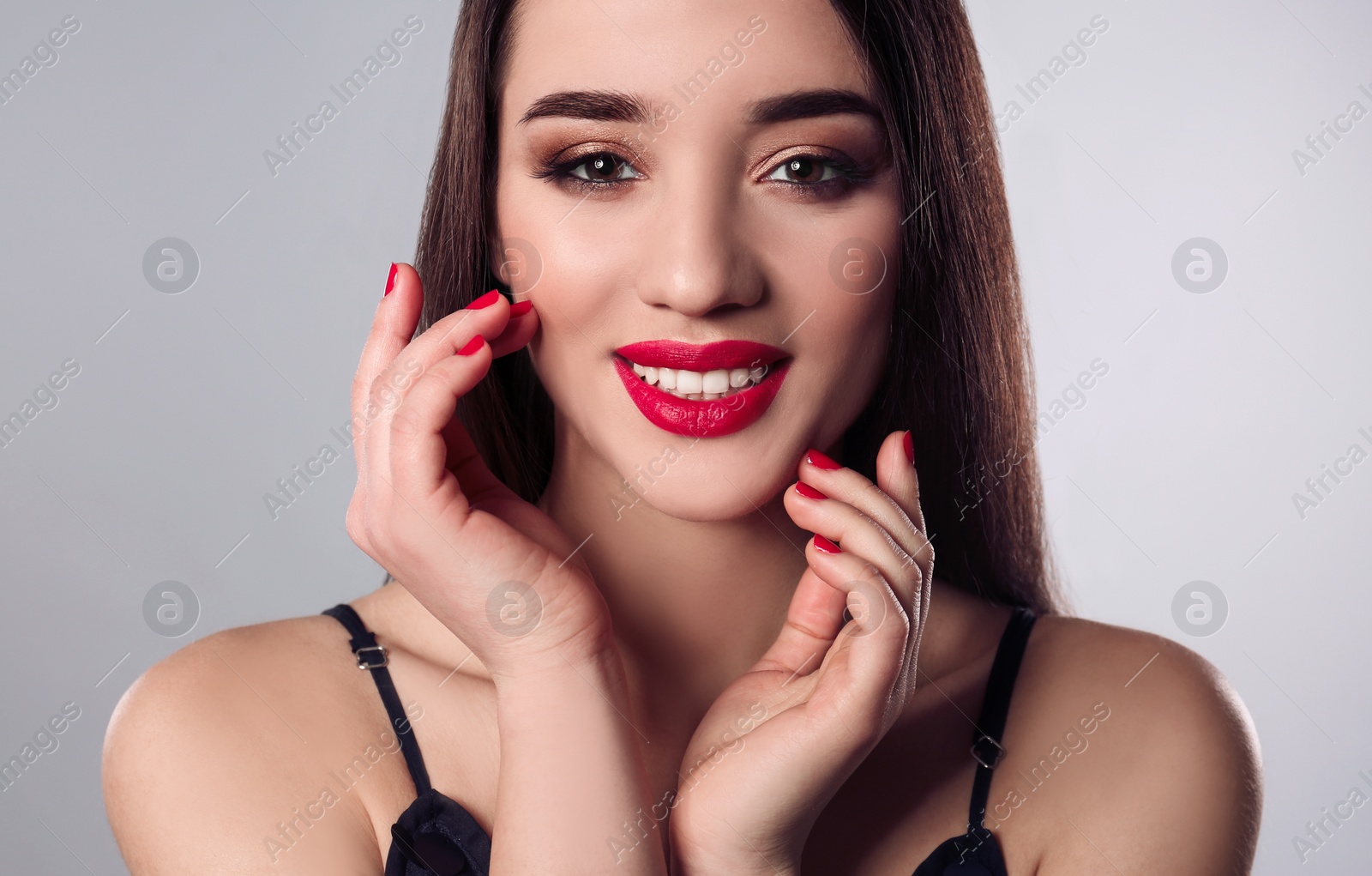Photo of Beautiful woman with stylish nail polish on grey background