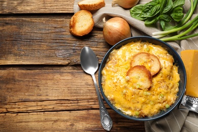 Tasty homemade French onion soup on wooden table, flat lay. Space for text