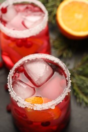 Photo of Tasty cranberry cocktail with ice cubes in glasses on table, closeup