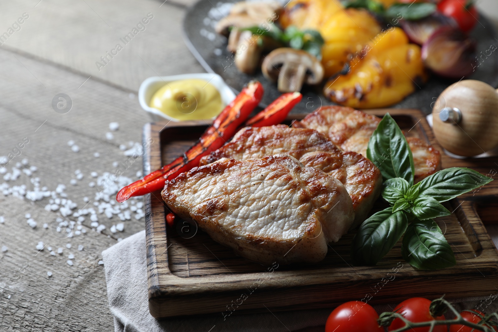 Photo of Delicious grilled meat and vegetables on wooden table, closeup