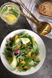 Delicious salad with cucumber and orange slices served on gray table, flat lay