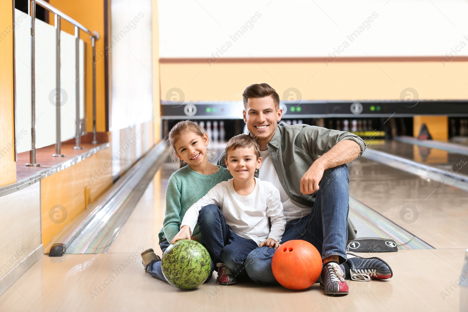 Photo of Happy family spending time together in bowling club