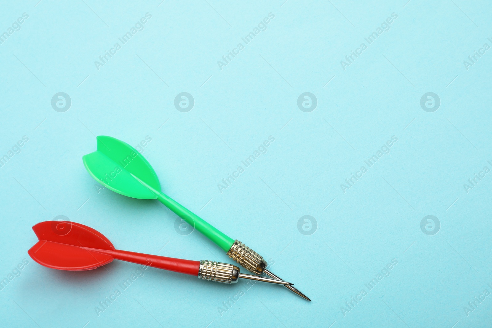 Photo of Plastic dart arrows on blue background, flat lay with space for text