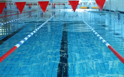 Photo of Modern swimming pool with blue water, indoors