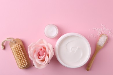 Jars of cream, sea salt and rose flower on pink background, flat lay with space for text. Body care products