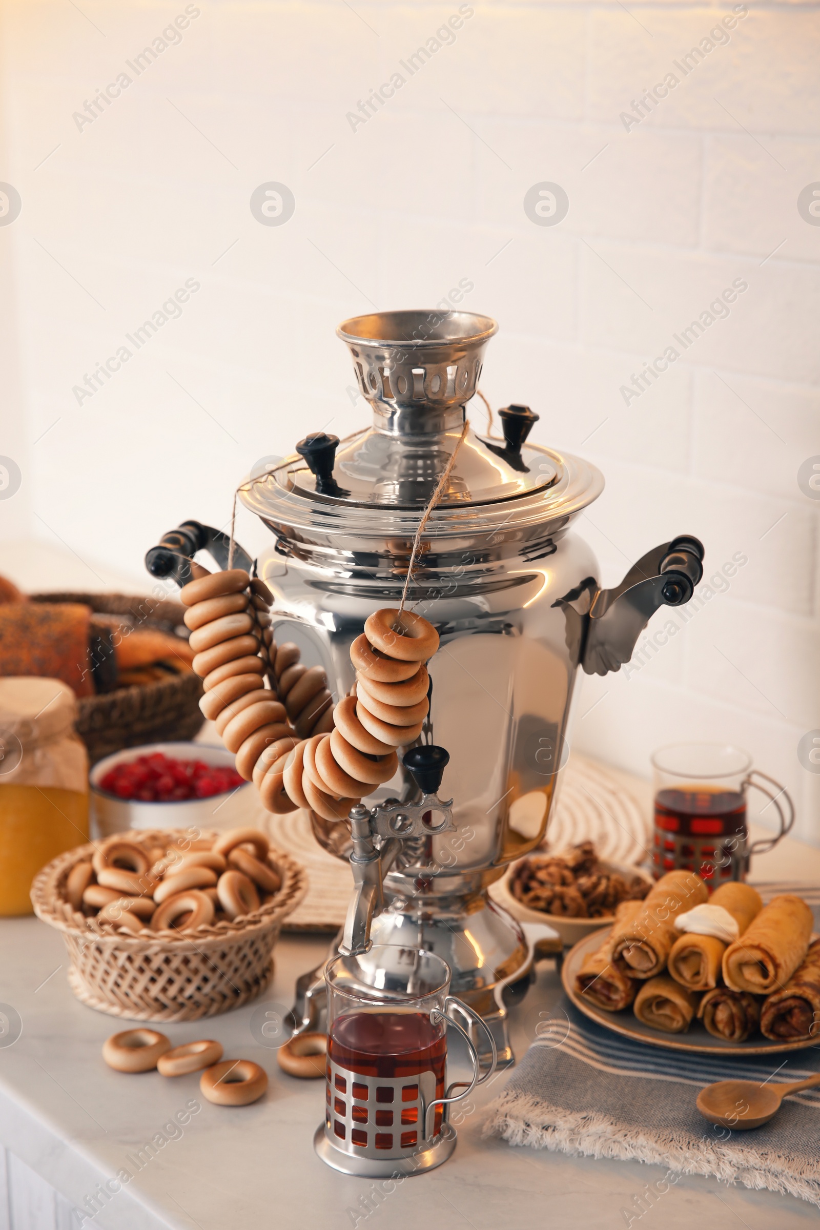 Photo of Traditional Russian samovar with treats on white table