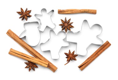 Photo of Different cookie cutters, cinnamon sticks and anise stars on white background, top view