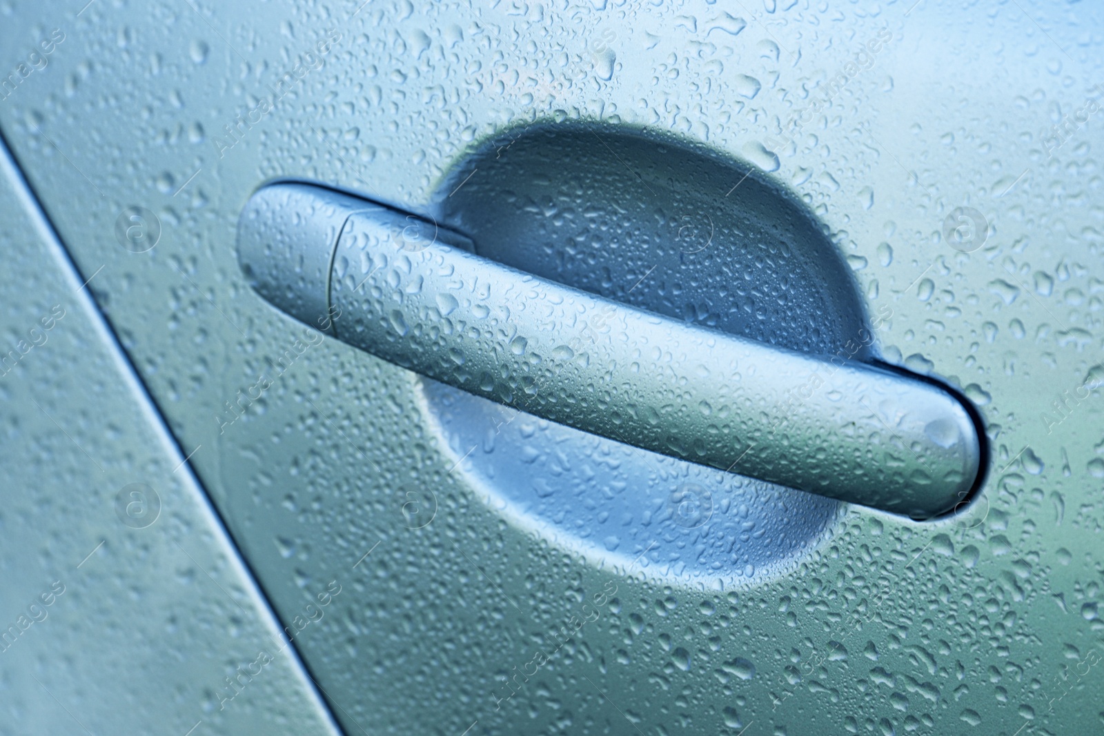 Photo of Closeup view of car door handle with water drops