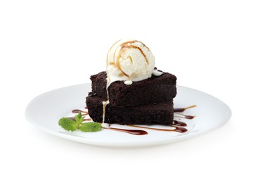 Tasty brownies with ice cream, mint and caramel sauce isolated on white