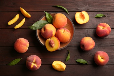 Fresh sweet peaches on wooden table, flat lay