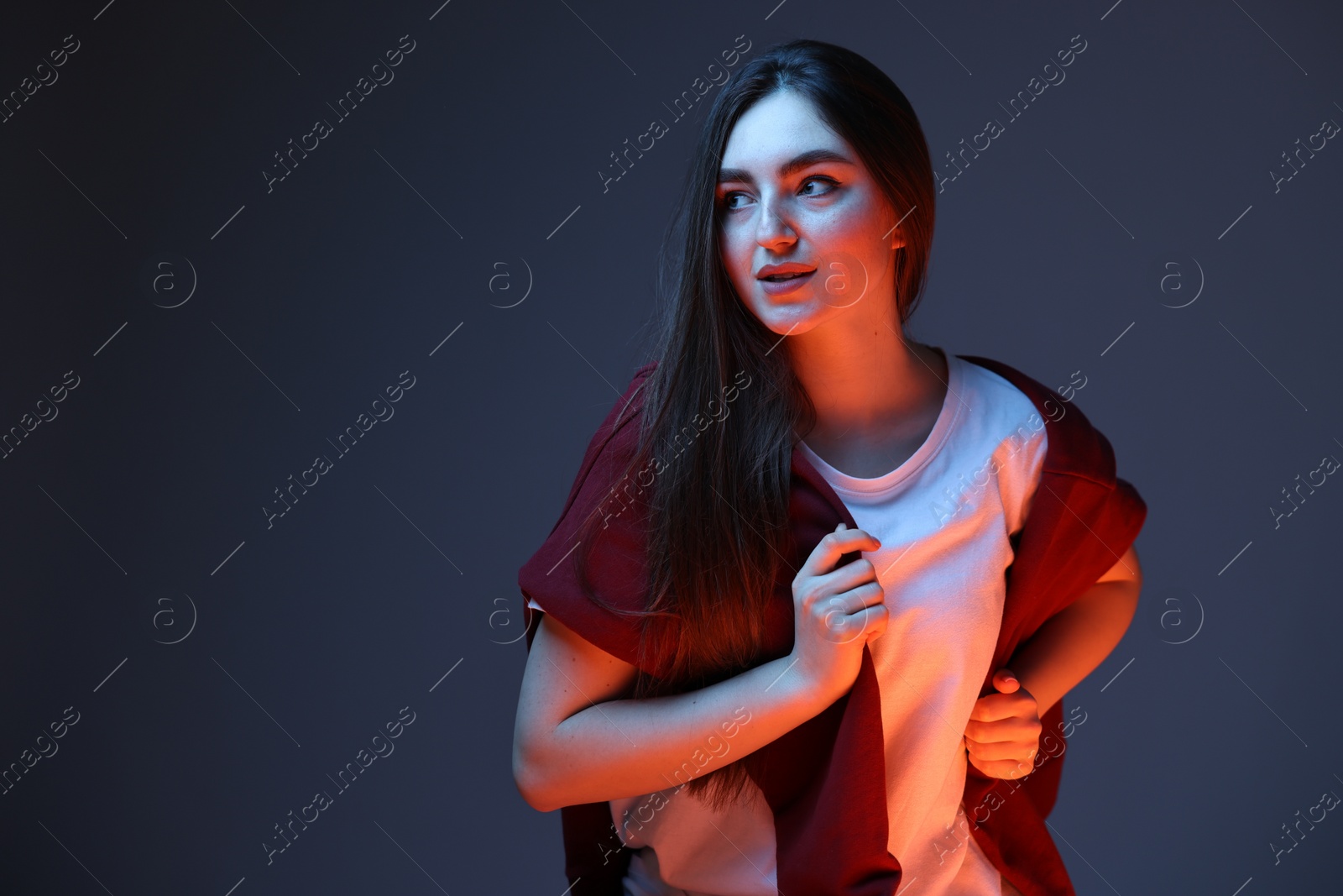 Photo of Portrait of beautiful woman on dark blue background in neon lights. Space for text