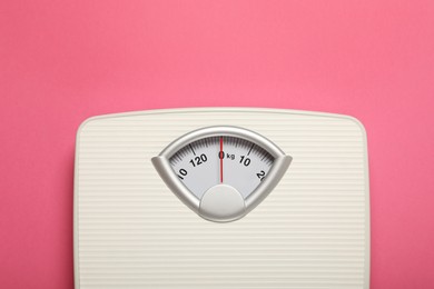 Photo of Weigh scales on pink background, top view with space for text. Overweight concept
