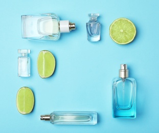 Flat lay composition with bottles of perfume and lime on color background