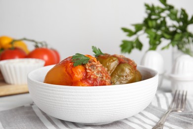 Photo of Delicious stuffed peppers with parsley in bowl on table