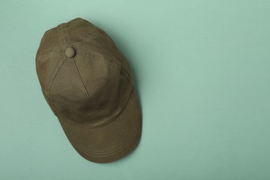 Photo of Baseball cap on light green background, top view. Space for text
