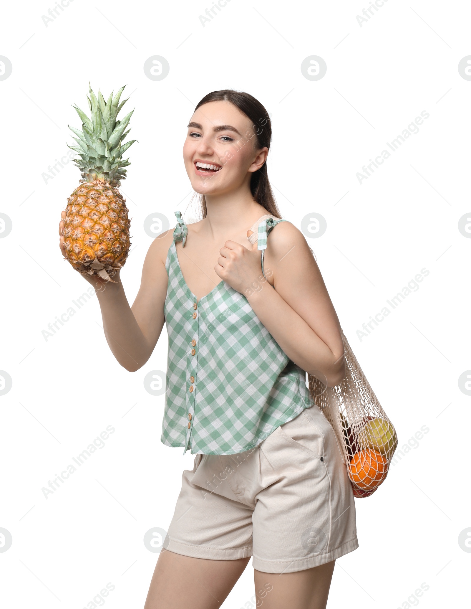 Photo of Woman with string bag of fresh fruits holding pineapple on white background