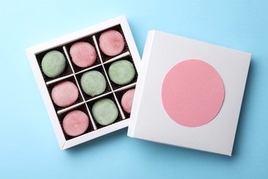 Many different delicious mochi in box on light blue background, top view. Traditional Japanese dessert