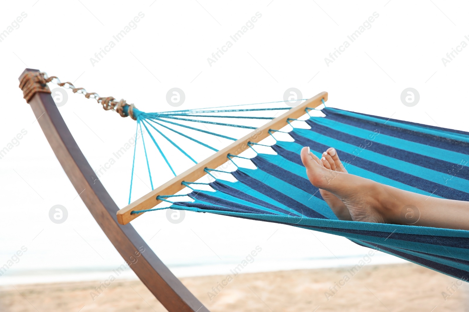 Photo of Young woman resting in comfortable hammock at seaside