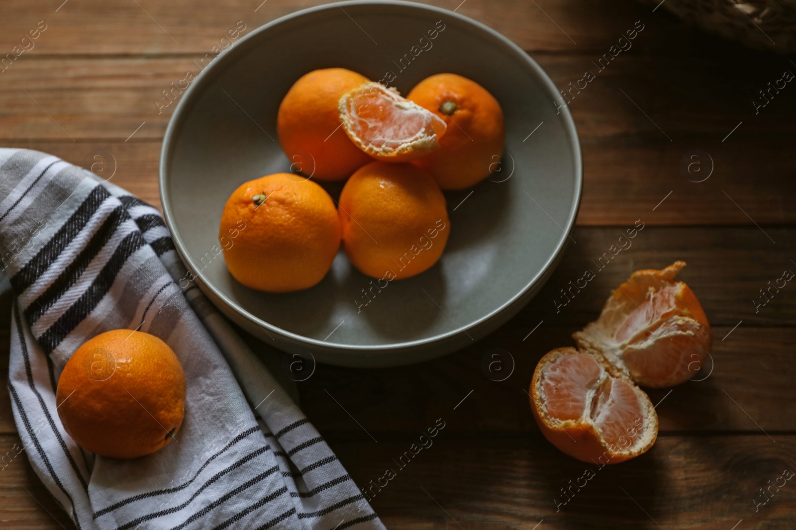 Photo of Fresh ripe tangerines on wooden table, above view