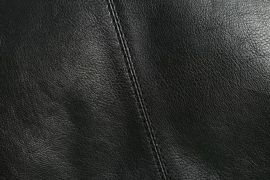 Photo of Black natural leather with seams as background, top view
