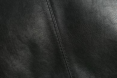 Black natural leather with seams as background, top view