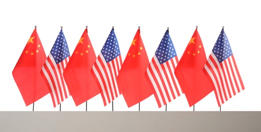 Photo of Many USA and China flags on white background. International relations