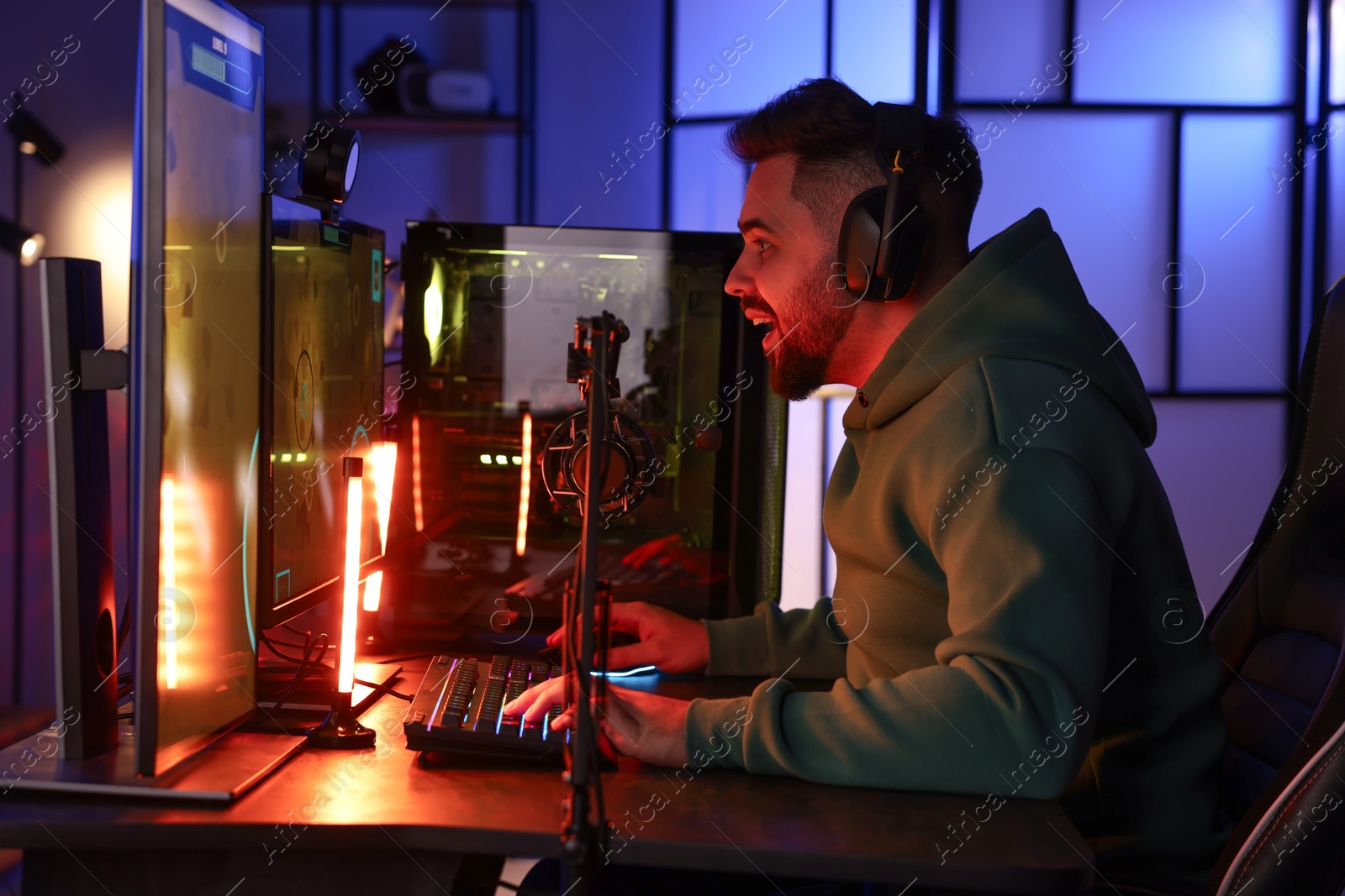 Photo of Man playing video games on computer at table indoors