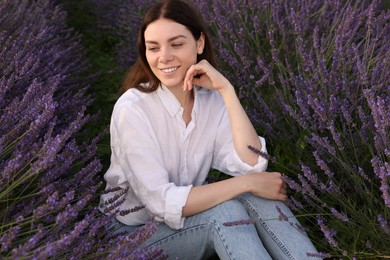 Smiling young woman among lavender plants outdoors